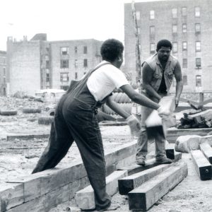 02469_EricWingate_Woman-and-Man-carrying-wood-pillar-b_w